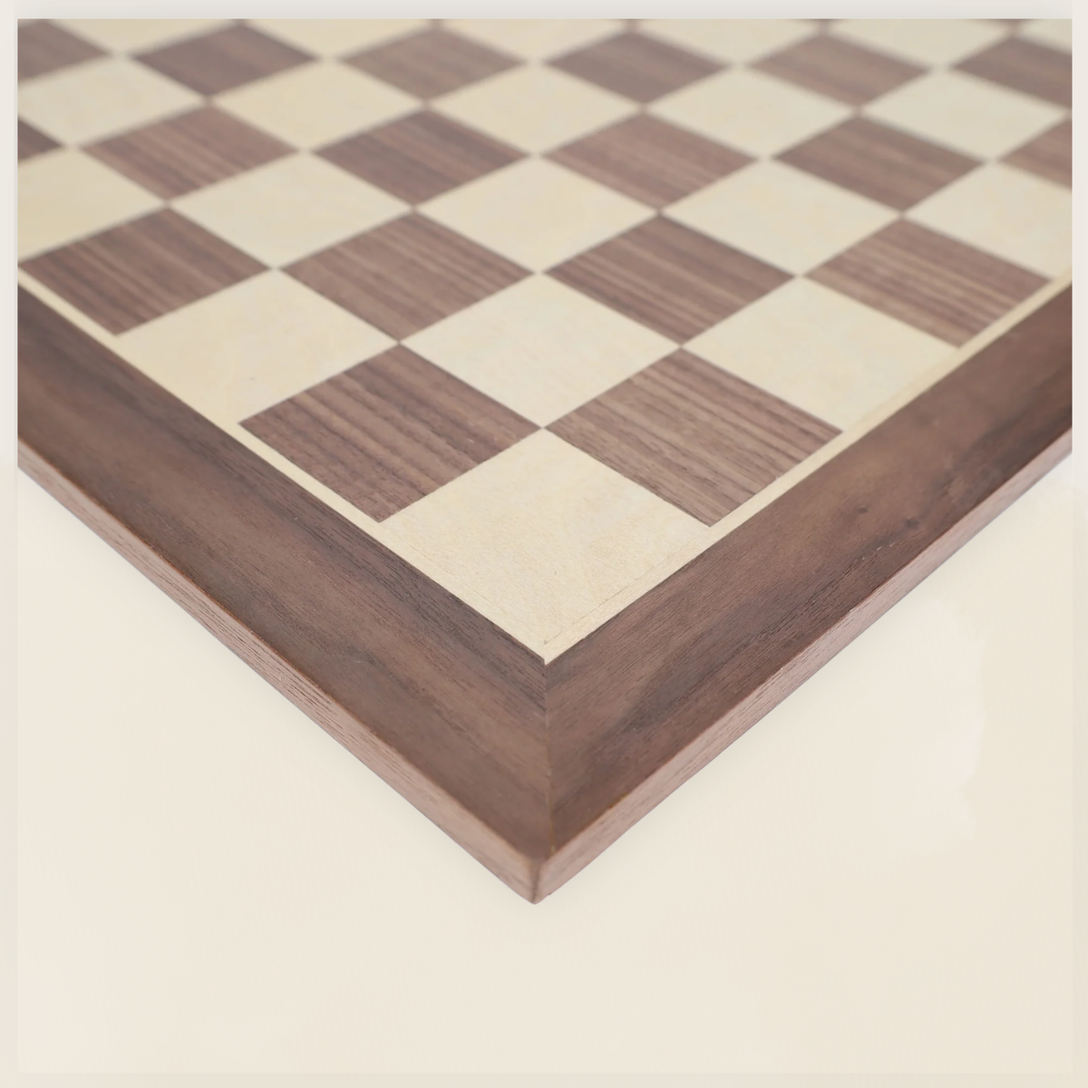 Close-up of walnut chess board corner showing wood grain, frame, and playing squares